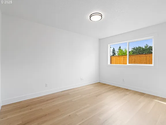 Bedroom with large window and new flooring